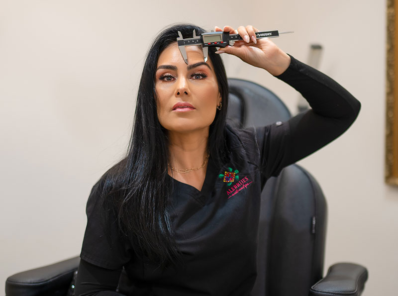 a woman holding a caliper to her forehead